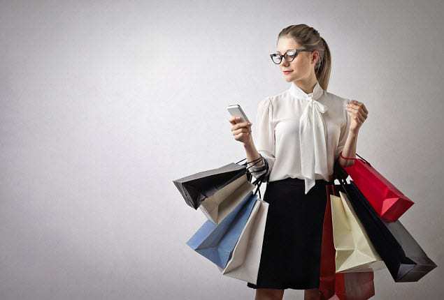 UK mobile commerce - Woman with shopping bags on mobile