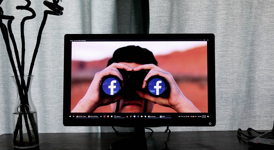 Facebook facial recognition - Man with binoculars - facebook logo