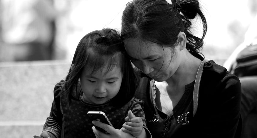 Apple use in China - woman and child looking at iPhone