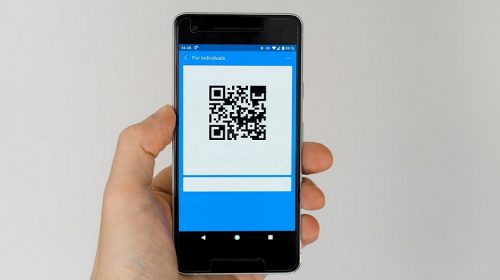 QR code adoption - person holding phone displaying QR code