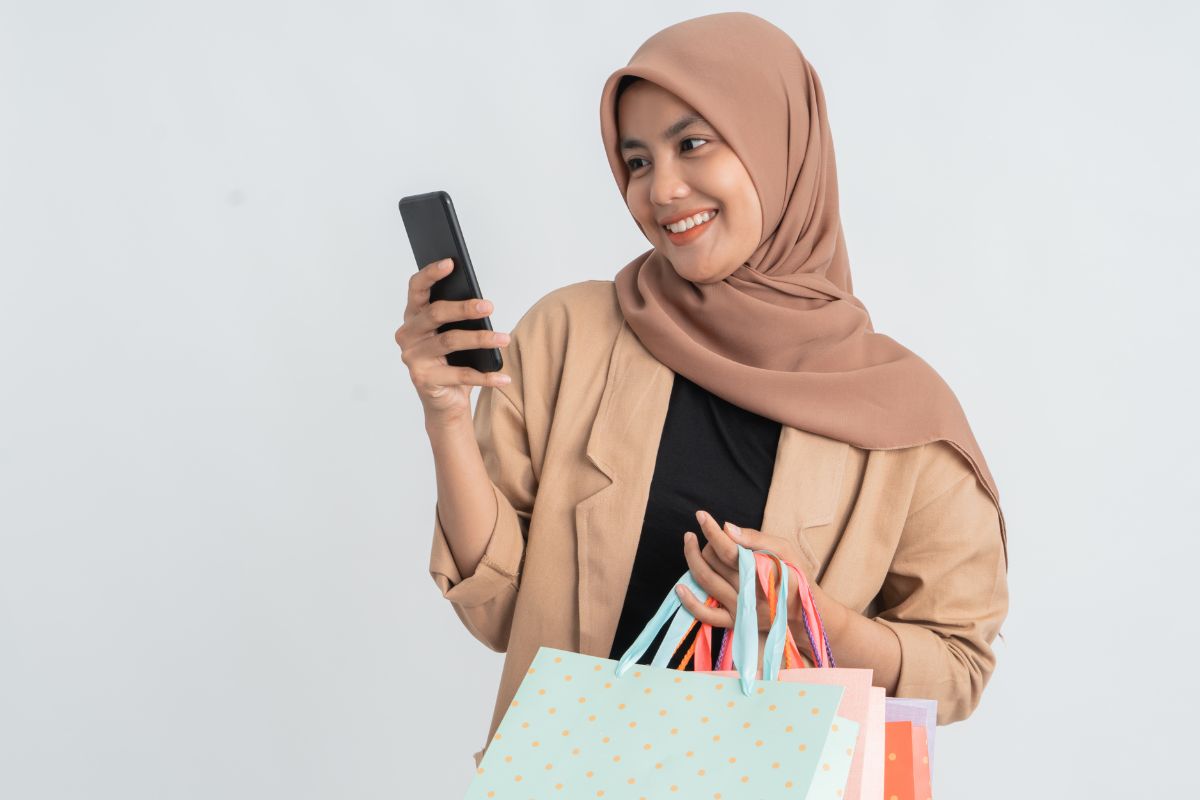Mobile shopping - Woman holding shopping bags looking at phone