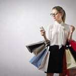 UK mobile commerce - Woman with shopping bags on mobile
