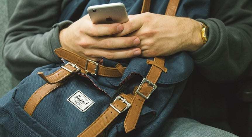 Mobile banking facial recognition - Man with iPhone and backpack