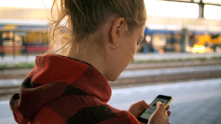 Mobile phone trend - woman walking looking at mobile phone