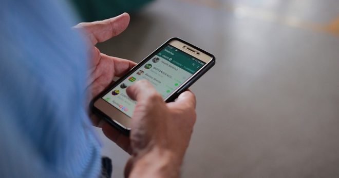 WhatsApp Data Sharing - Person using WhatsApp on phone