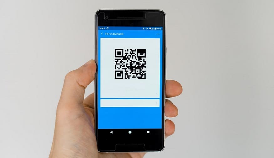 QR code adoption - person holding phone displaying QR code