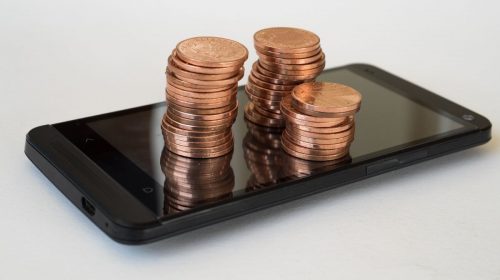 Mobile commerce sales - pennies on top of phone