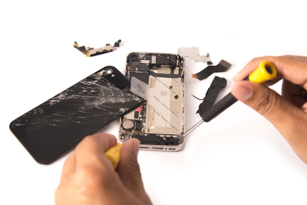 Electronic waste - Person taking apart broken phone