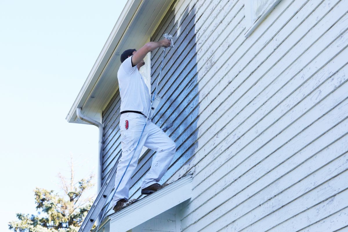 Energy technology - Person painting house exterior