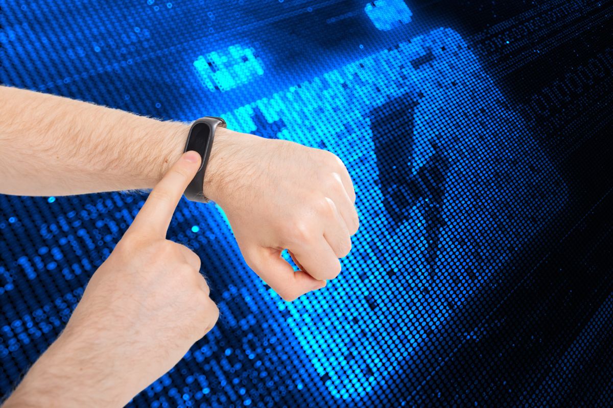 Fitbit Charge 5 - Image of Person touching Fitbit device screen with battery in background