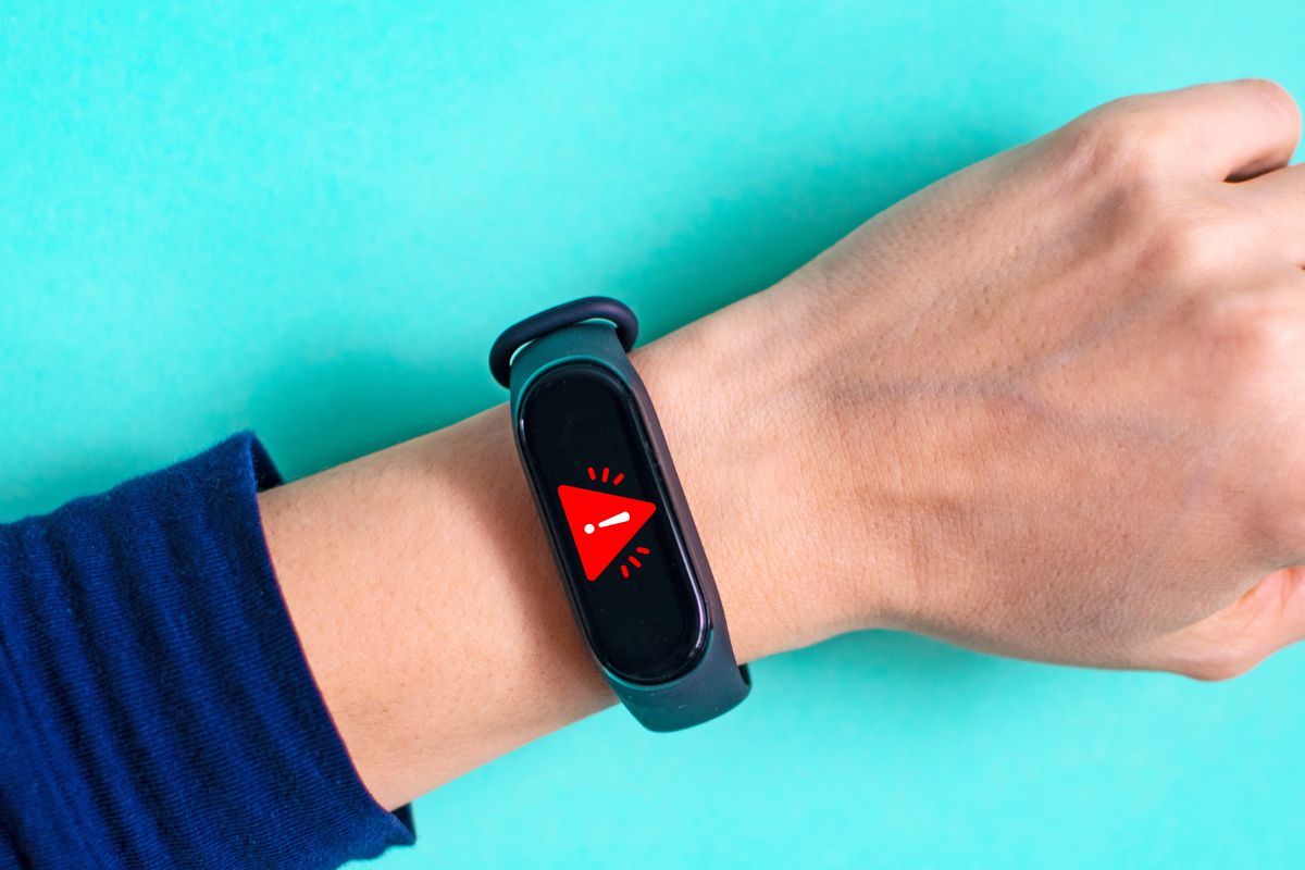 Mobile wallet - Person wearing older Fitbit model with warning sign
